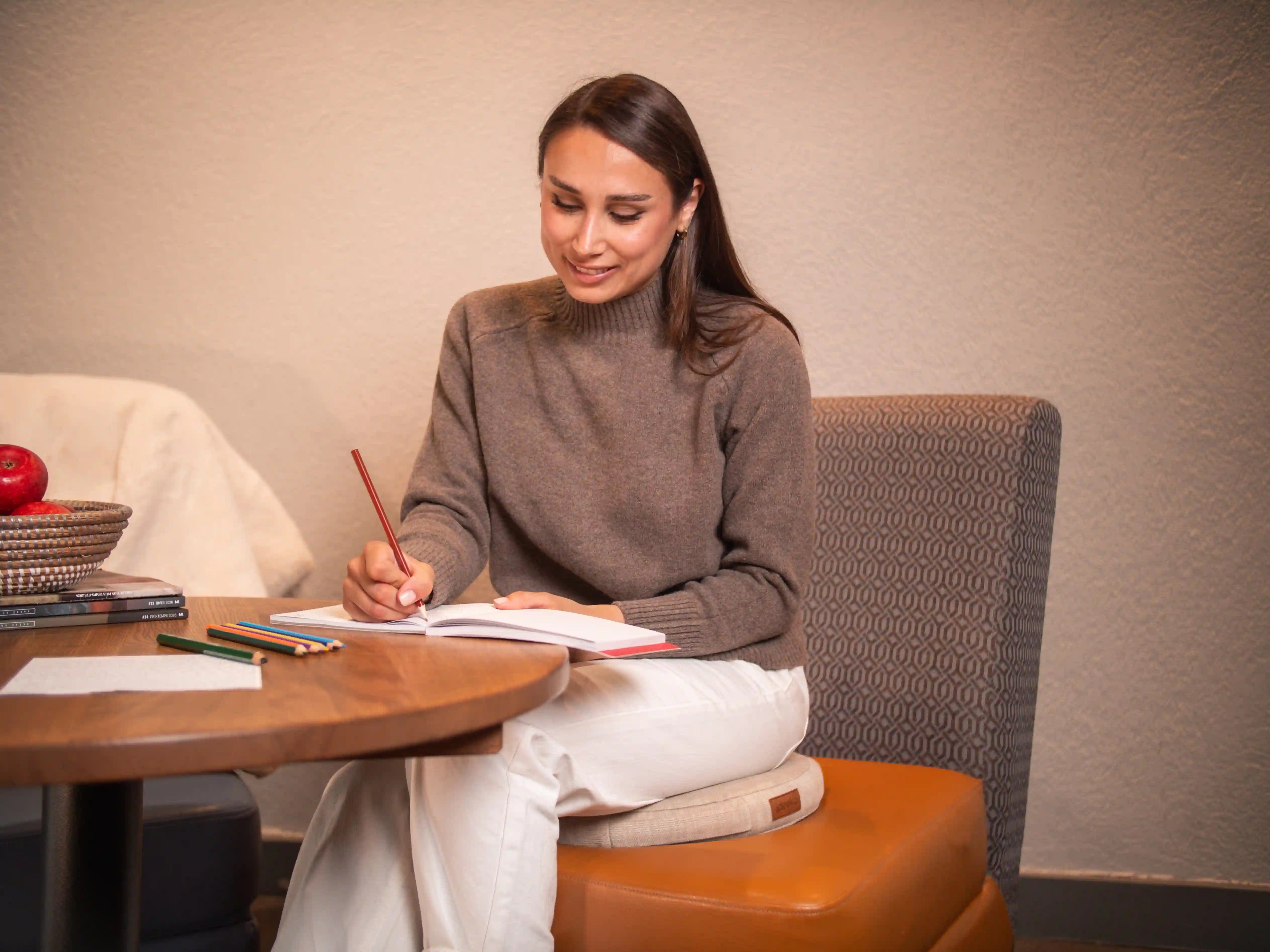 Une femme souriante et concentrée travaillant de longues heures à la maison grâce au confort de son assise active.