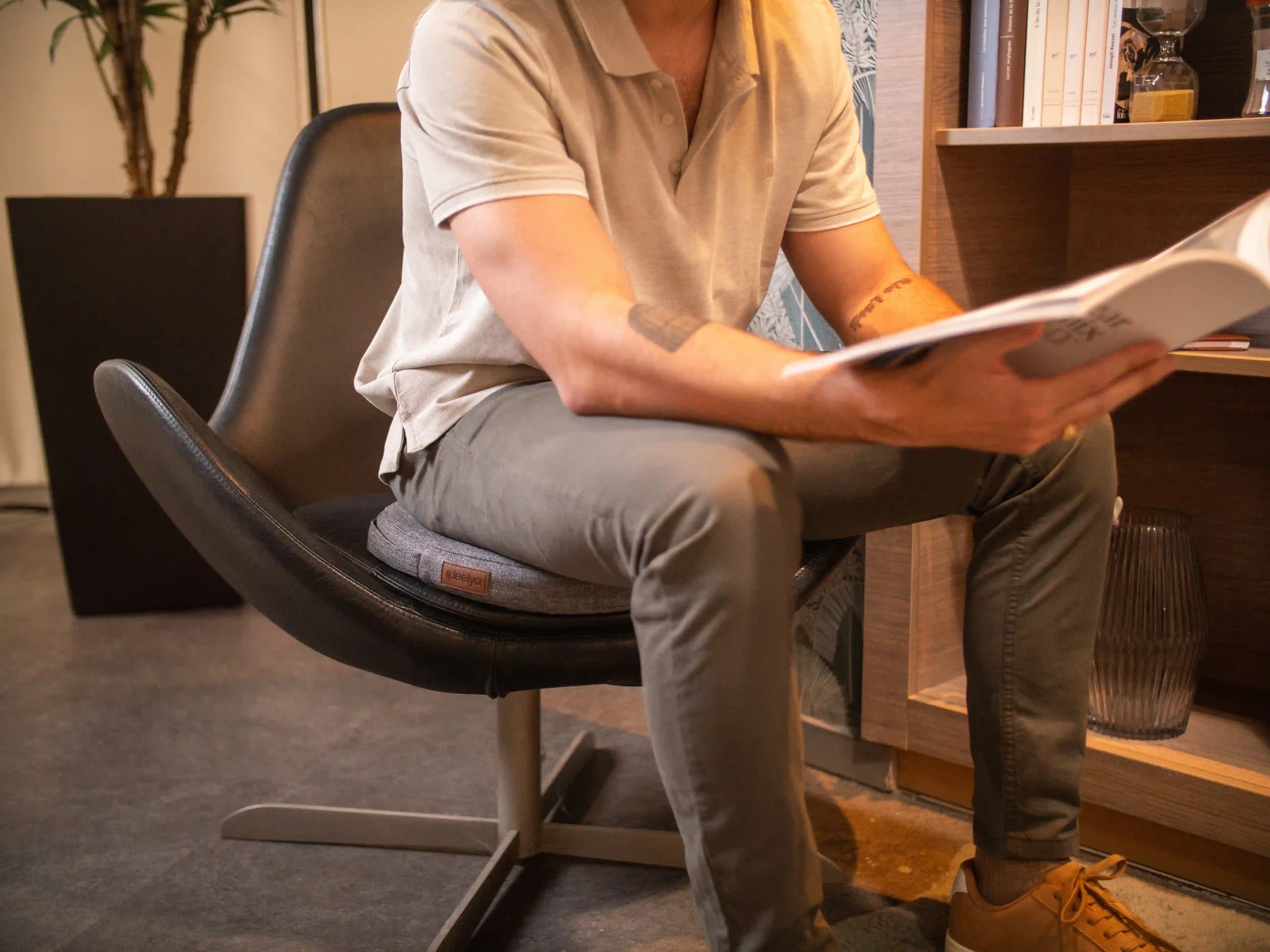 Homme assis sur un support d'assise active DEELYA gris Seren, conçu en France et fabriqué en Europe, de manière qualitative.