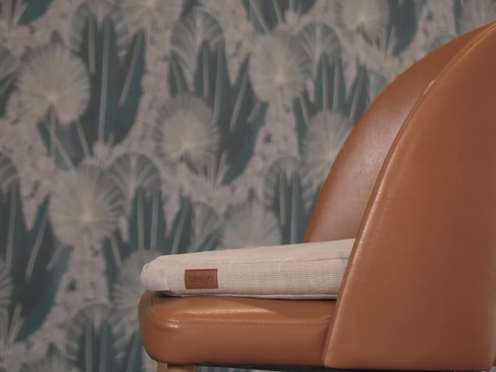 Vidéo montrant une femme s'installant confortablement sur son support d'assise active DEELYA positionné sur un fauteuil. Son bassin est animé d'un micro-mouvement fluide et naturel pendant qu'elle consulte sa tablette.