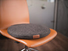Le support d'assise active DEELYA en tissu chiné brun profond Terra sur un siège de bureau à roulettes.