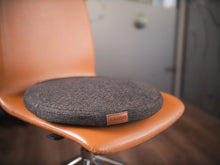 Le support d'assise active DEELYA en tissu chiné brun profond Terra sur un siège de bureau à roulettes.