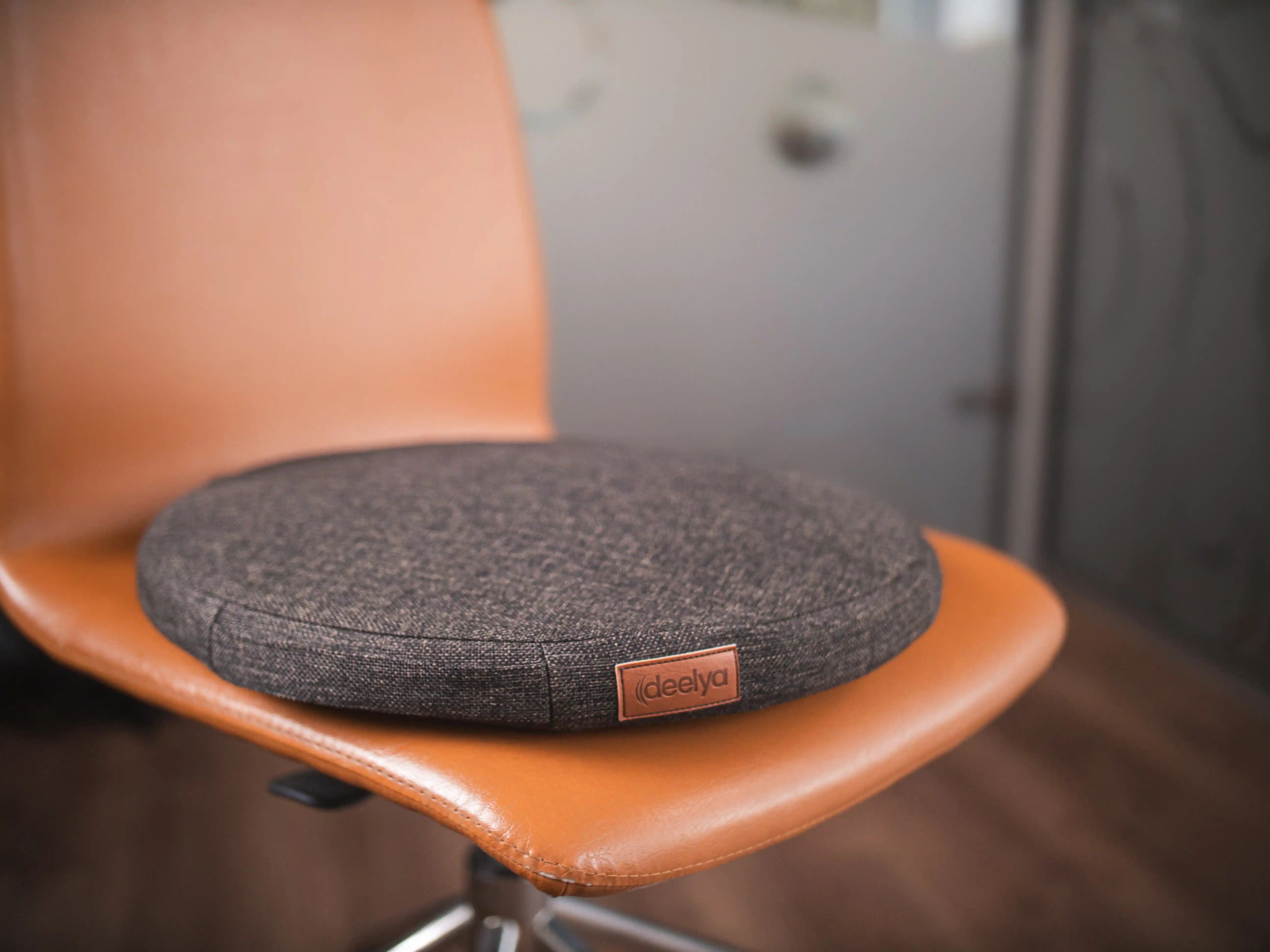Le support d'assise active DEELYA en tissu chiné brun profond Terra sur un siège de bureau à roulettes.